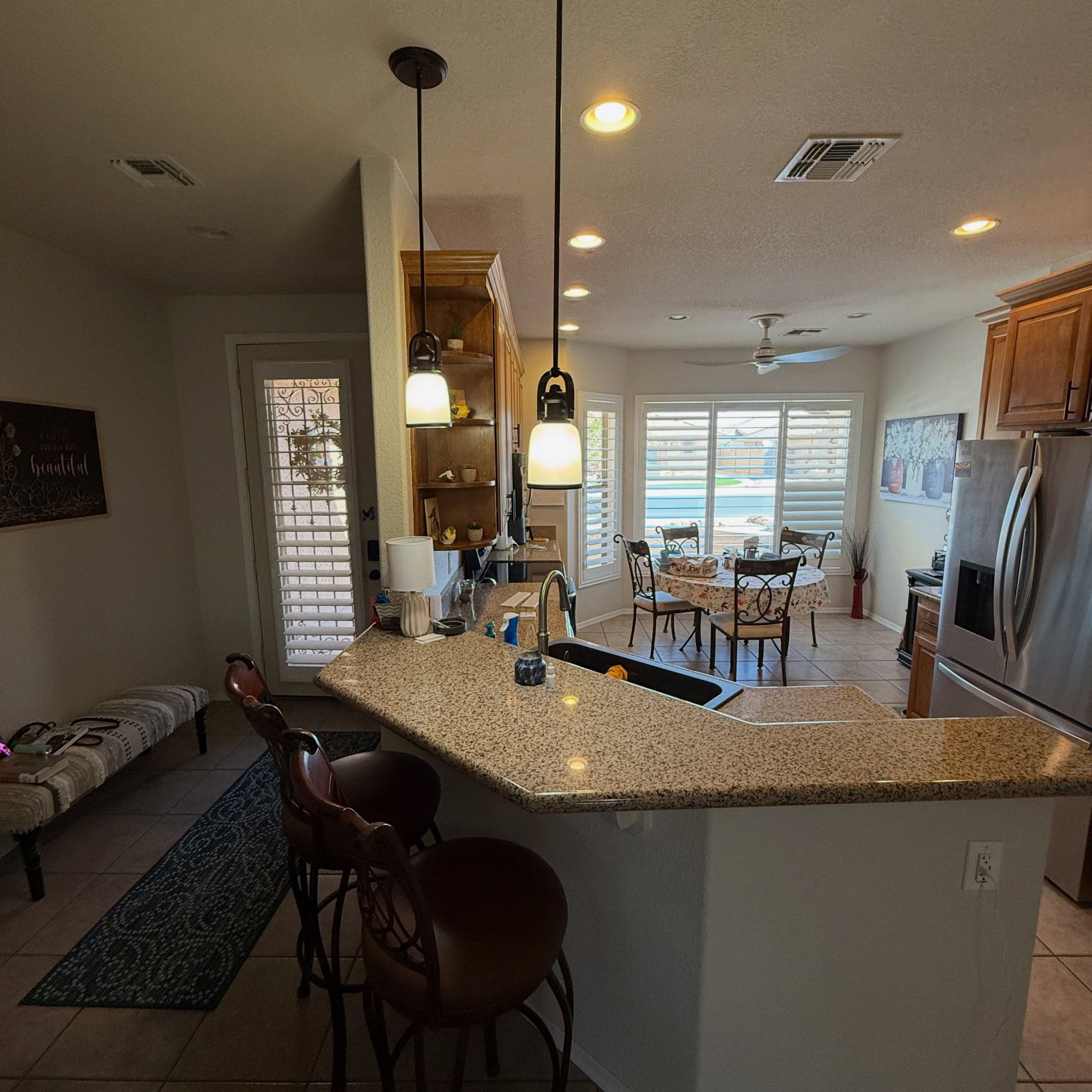 After: repainted cabinets, quartz island and pendant lighting.