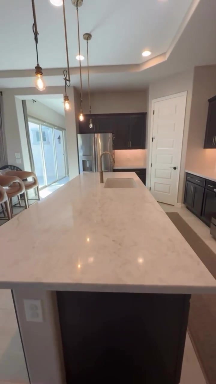 Light veined countertop on the island with the undermount sink.