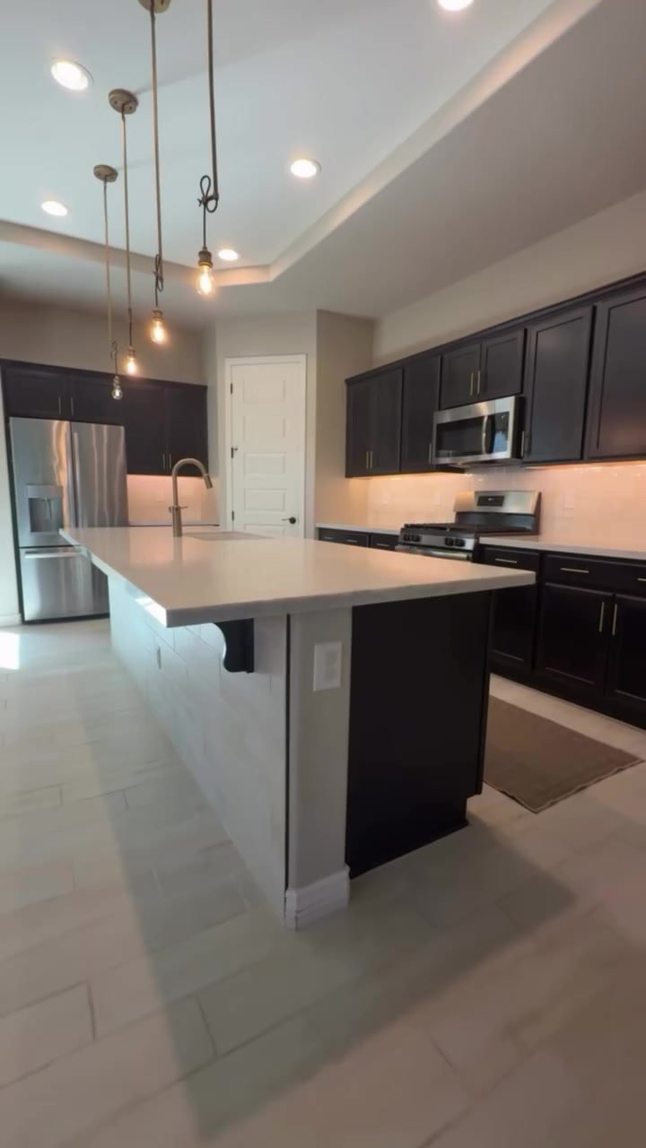 The island with its new countertop under the pendant lights.